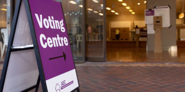 Purple AEC sign pointing to a voting centre