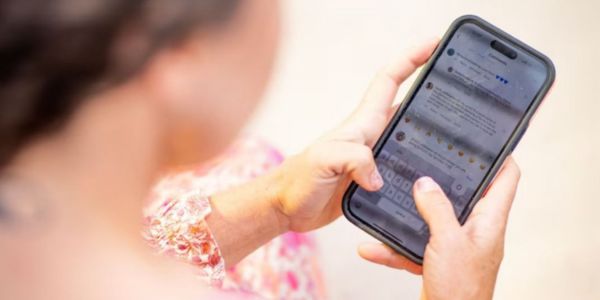 Blurred over-shoulder image of person looking at phone screen