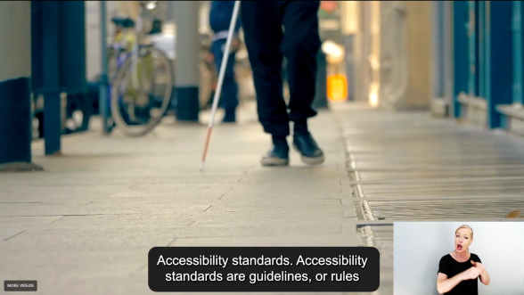 Screenshot from Amy Hogan video showing a blind person walking with a white cane sml