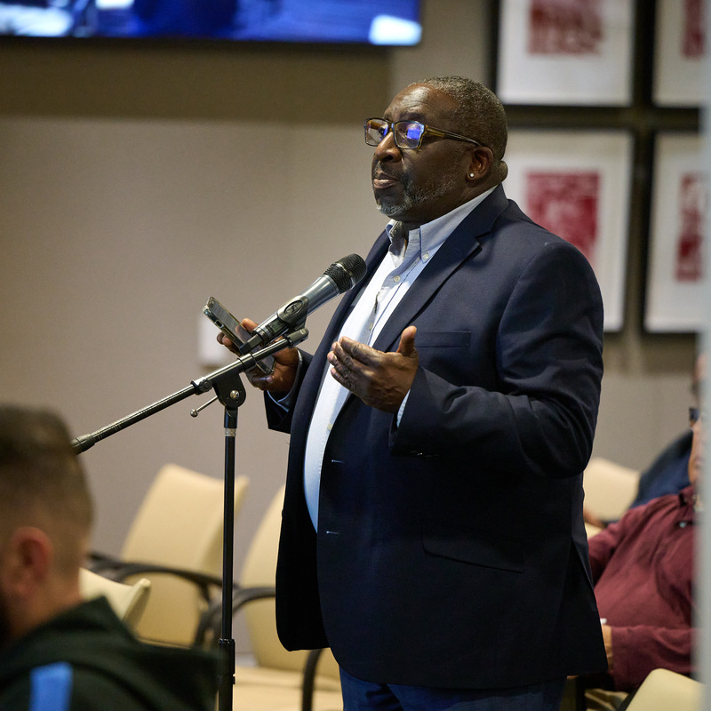 Ahmad speaking at a microphone