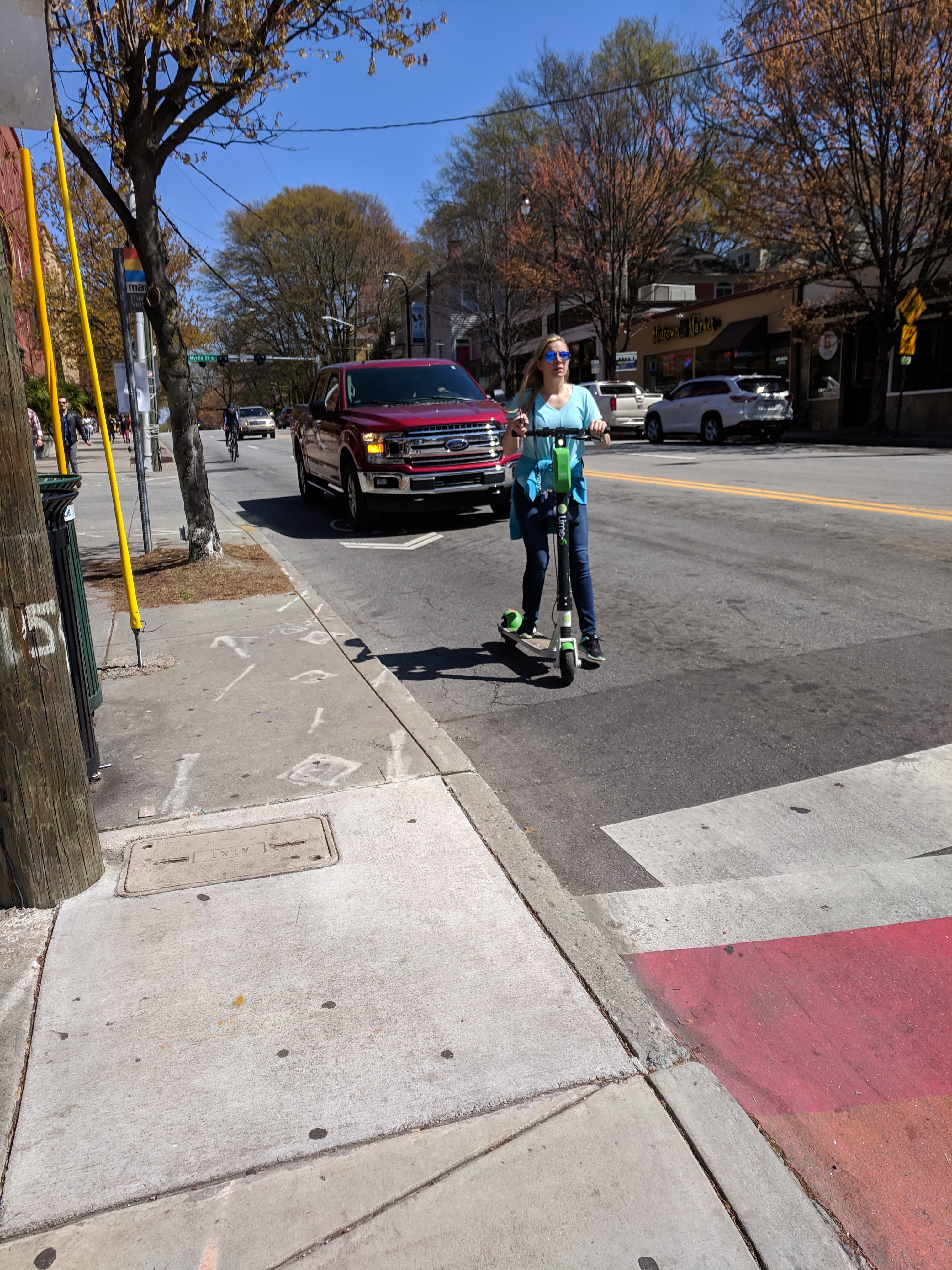 Person on a scooter in front of a truck on a street without safety improvements