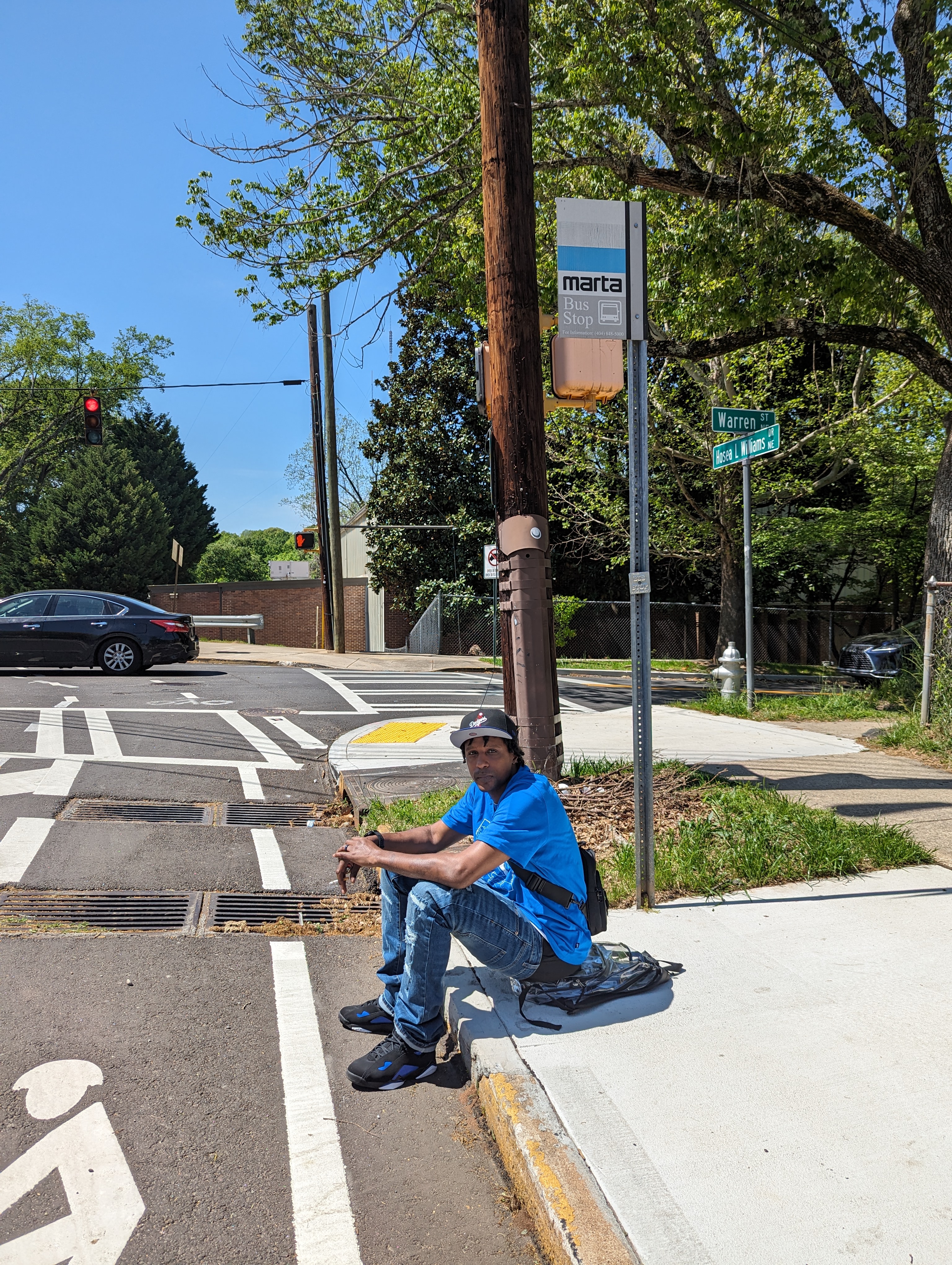 Person sitting on the ground waiting for a MARTA bus