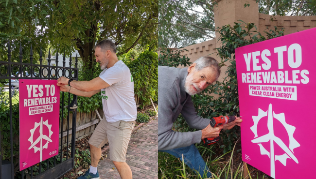 Two men installing yard signs