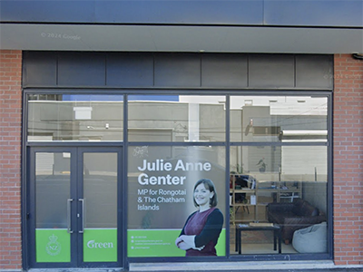 An image of the outside of the Rongotai Electorate office. It is a modern building with brick trim, and a picture of Julie Anne Genter in the window, with Green branding.