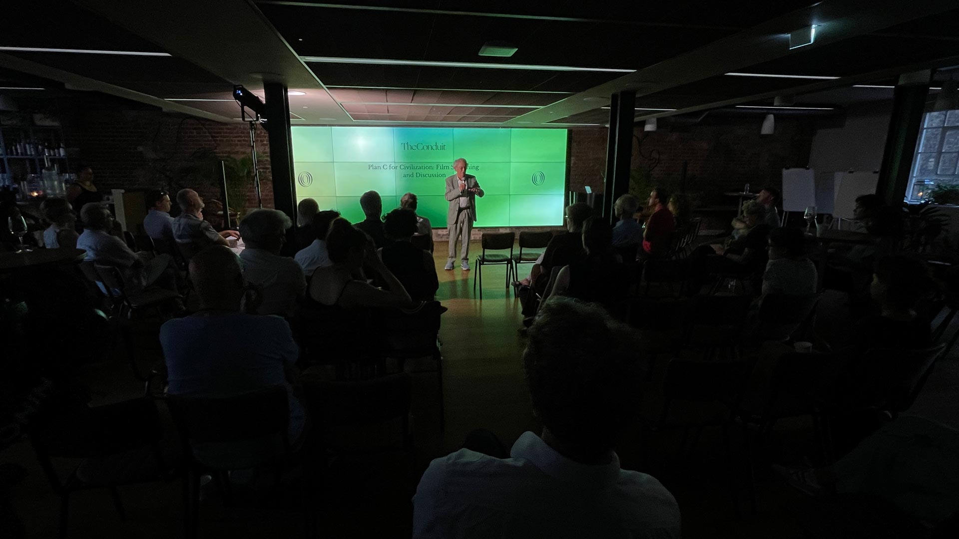 Sir David King in front of a screen saying: 'The Conduit: Plan C for Civilization'