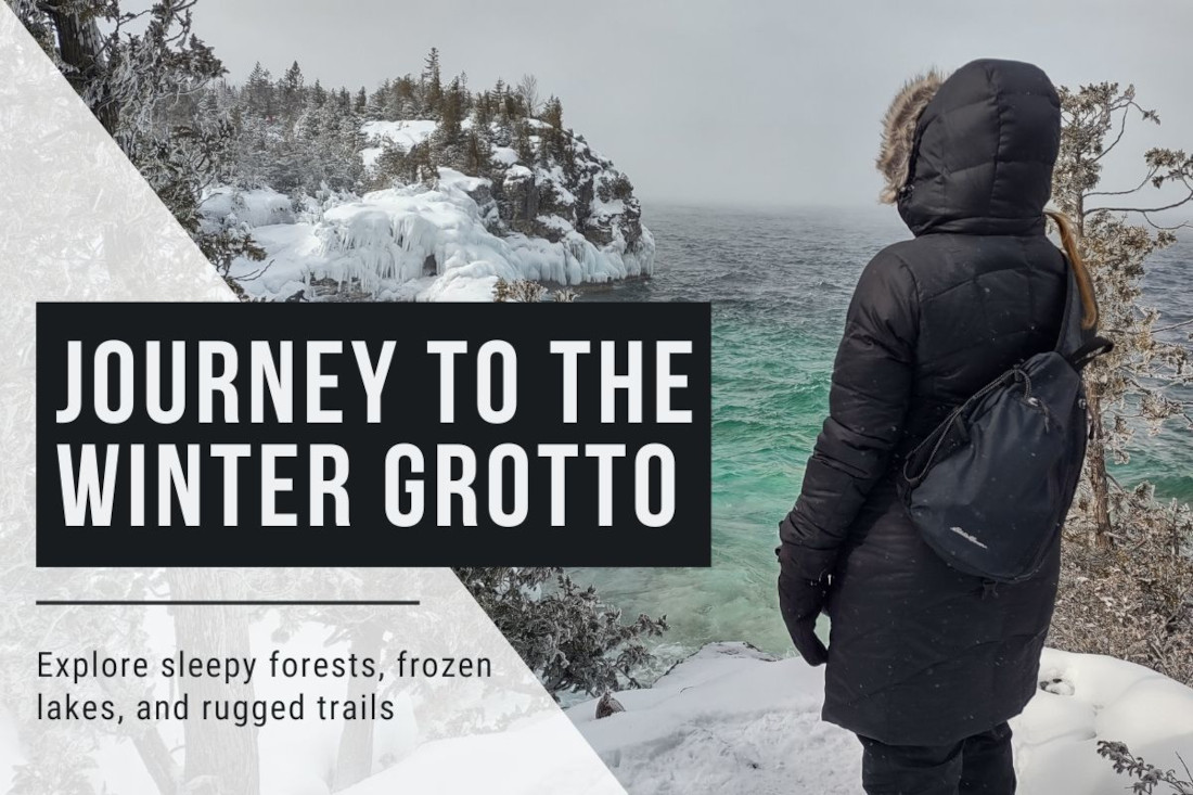 Person in a winter coat looks over Georgian Bay from the top of snowy cliffs at The Grotto on the Bruce Peninsula.