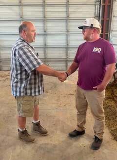 Christian and Dairy Farmer Dan speaking in the barn