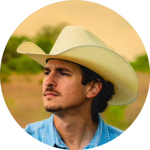 Clayton in cowboy hat, looking in the distance
while in a field. 