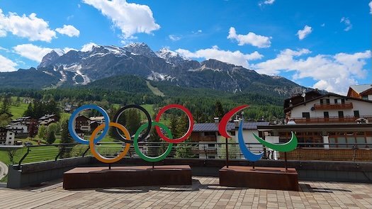 Milano-Cortina 2026 Winter Olympics and Paralympics logos with a view of the Dolomites in Cortina d'Ampezzo, Italy.