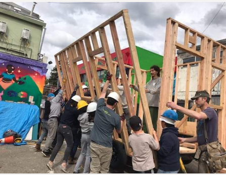 People lifting walls creating Richmond Tiny Home Village