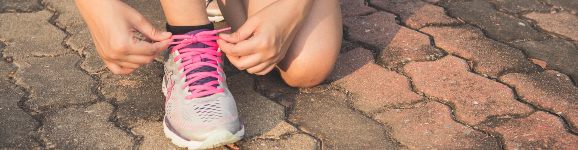 Woman lacing running shoe