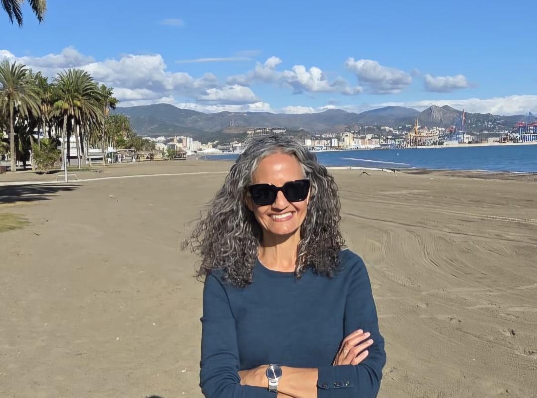 Tovah Calderon standing in front of a beach and mountains