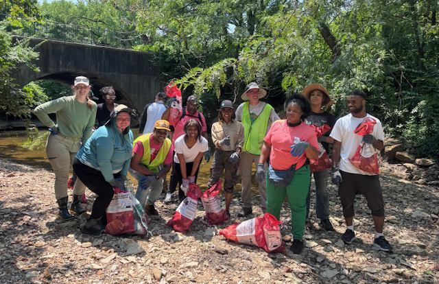 Group of volunteers pose by creek