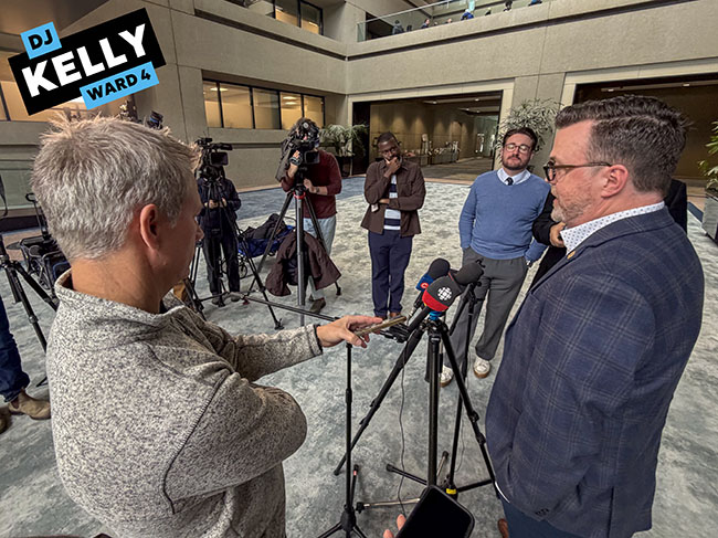 Img text: Cllr. DJ Kelly speaks to the media outside of Calgary Council Chambers on March 31, 2026. (Aryn Toombs / Ward 4)