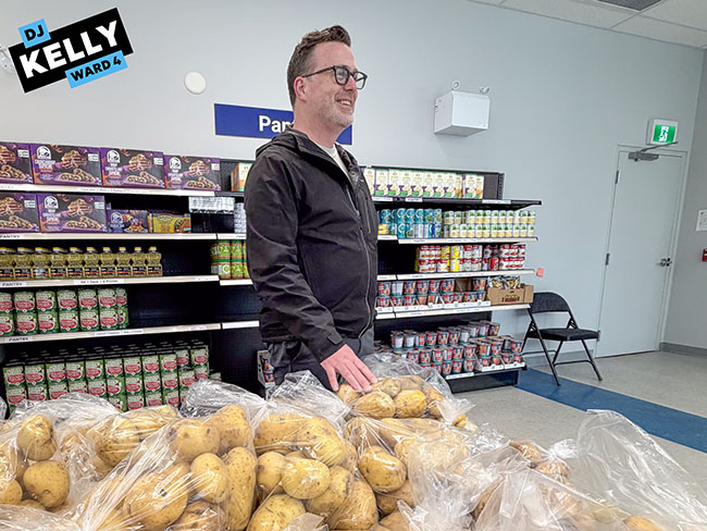 Img Alt: Cllr. Kelly looks at one of the fresh food options available for clients of the downtown Calgary Food Bank location on May 20, 2026. (Aryn Toombs / Ward 4)