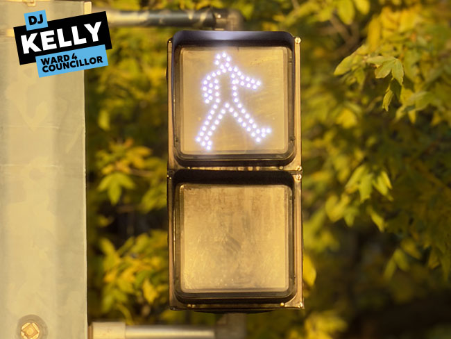 Img Alt: A pedestrian crossing signal indicates pedestrians can cross the road on Sept. 21, 2026. (Aryn Toombs / Ward 4)