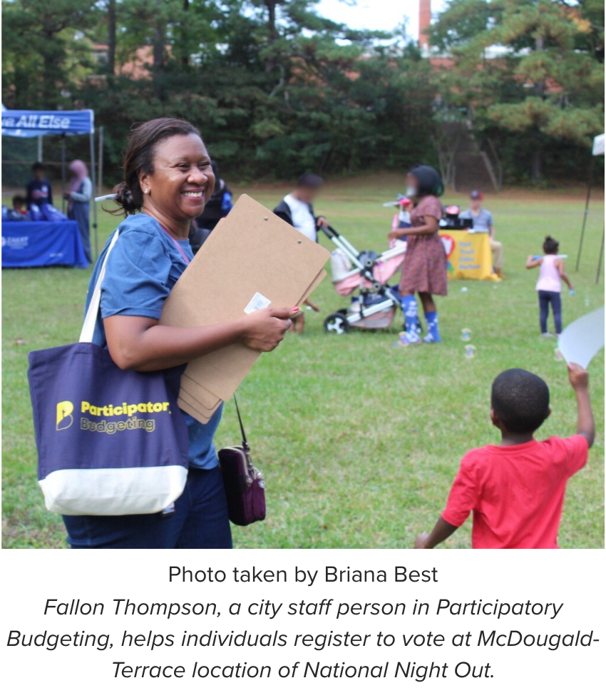 Fallon Thompson, a city staff person in Participatory Budgeting, helps individuals register to vote at McDougald-Terrace location of National Night Out.