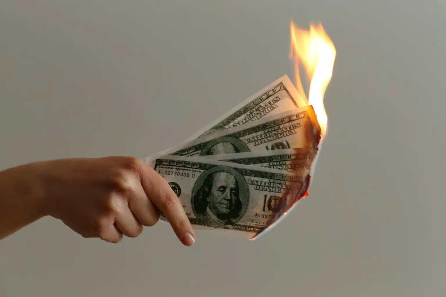 Picture of a hand holding burning money