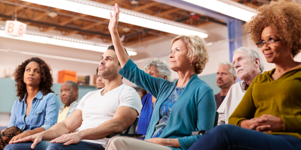 woman raising hand at community meeting