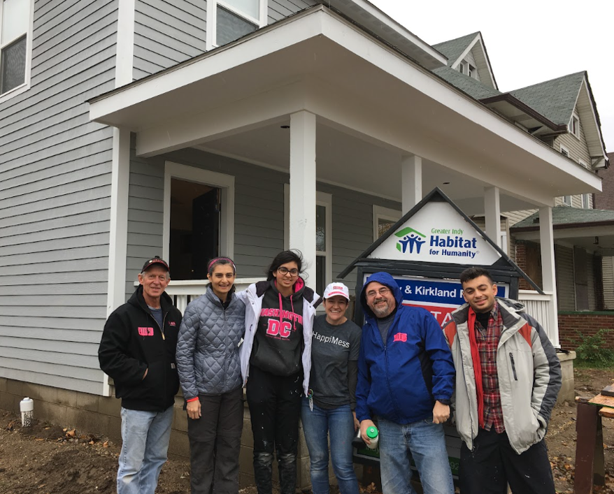 A group of people standing in front of a house

AI-generated content may be incorrect.