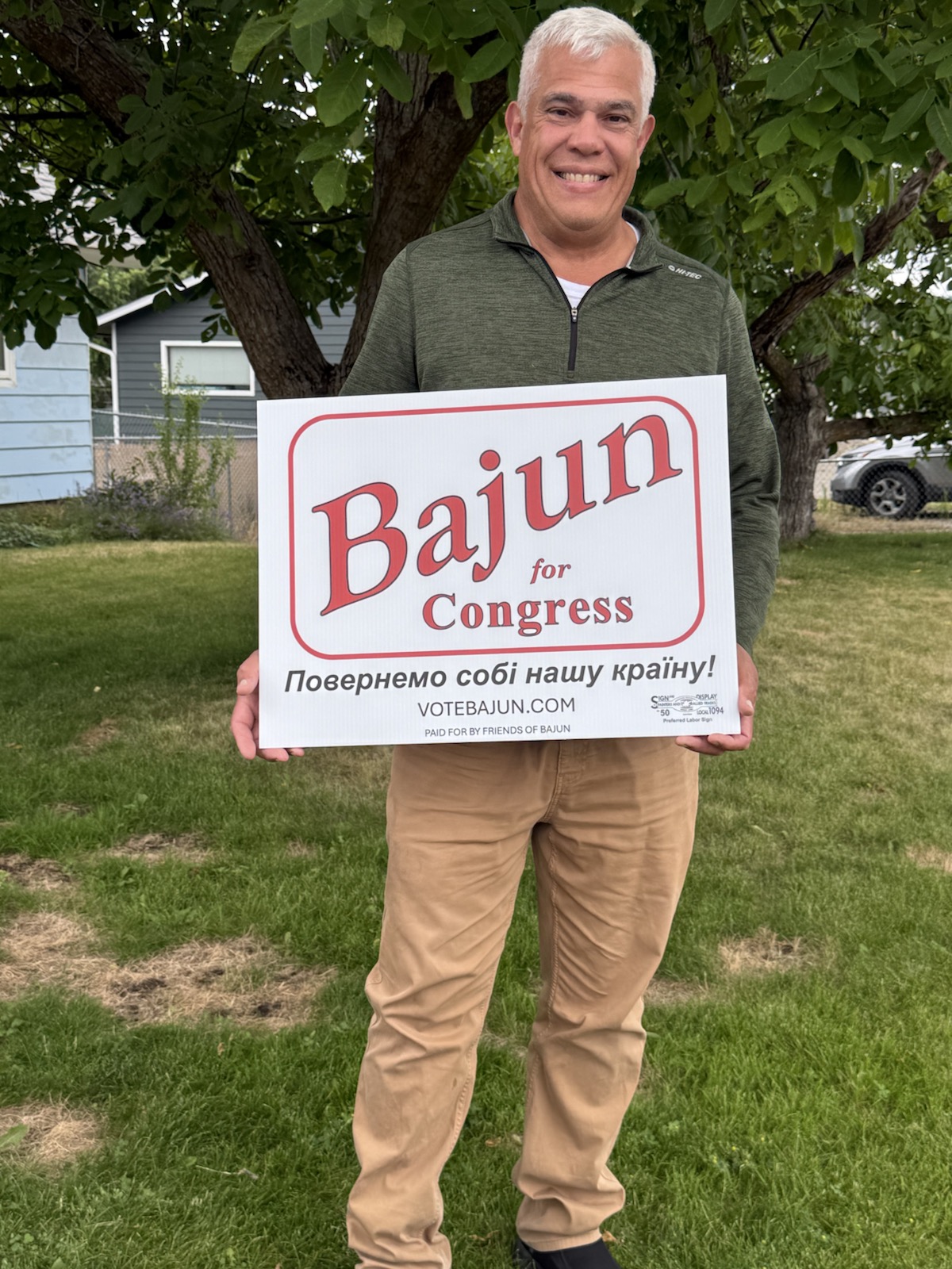 Eastern Washington congressional candidate Bajun Mavalwalla holding a Russian-language campaign sign.