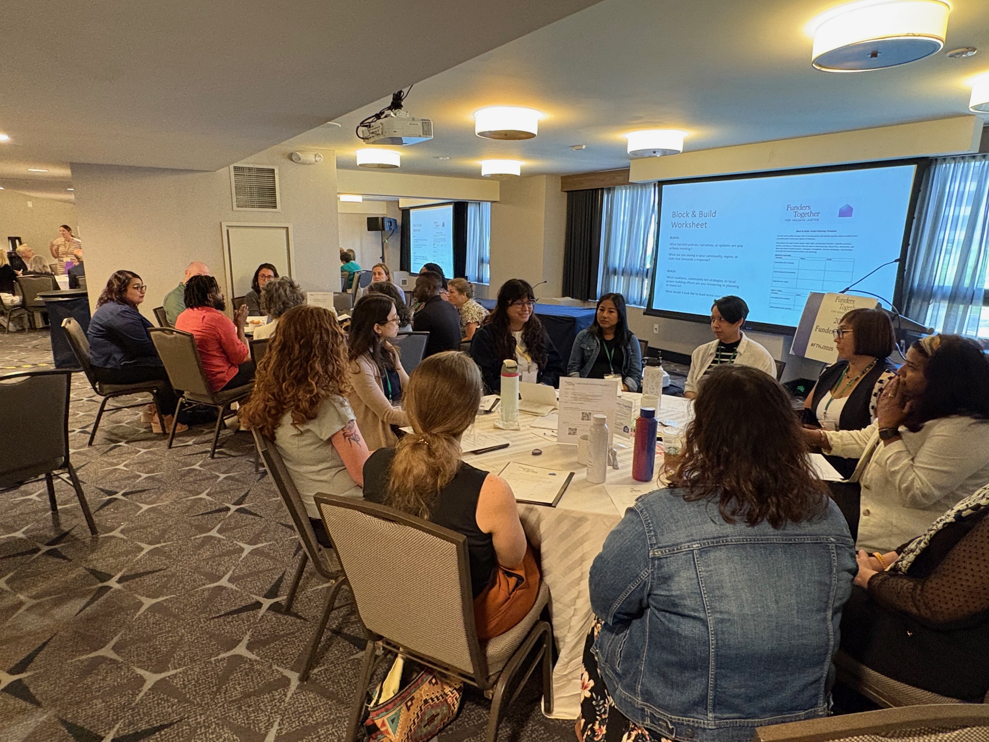 groups of multiracial people sit at two different tables talking to each other