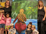 Photo of Katherine Laco and Susan Murray with students and murals