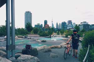 Man with bike walking through green infrastructure