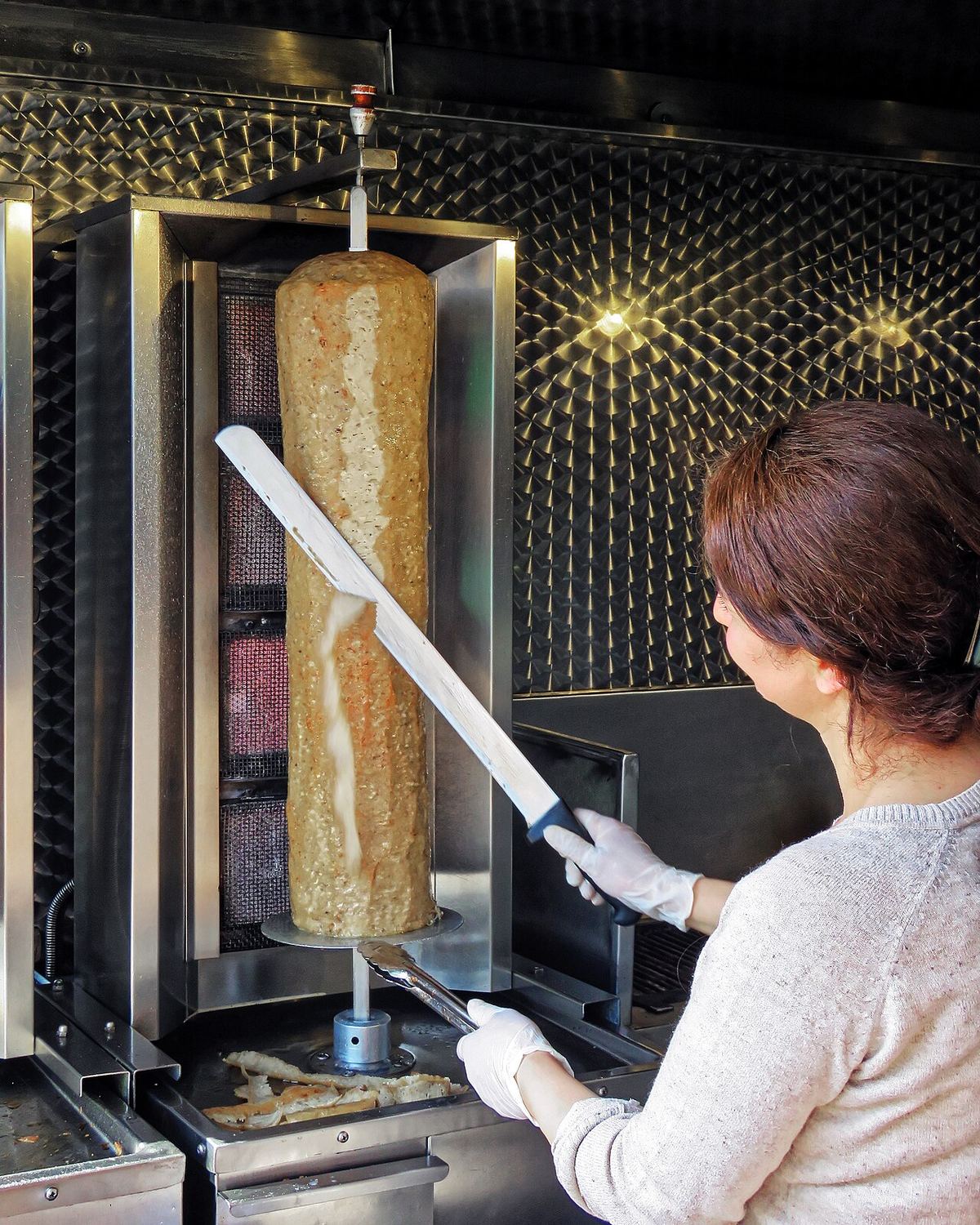 Slicing a lamb doner kebab at a London kebab house