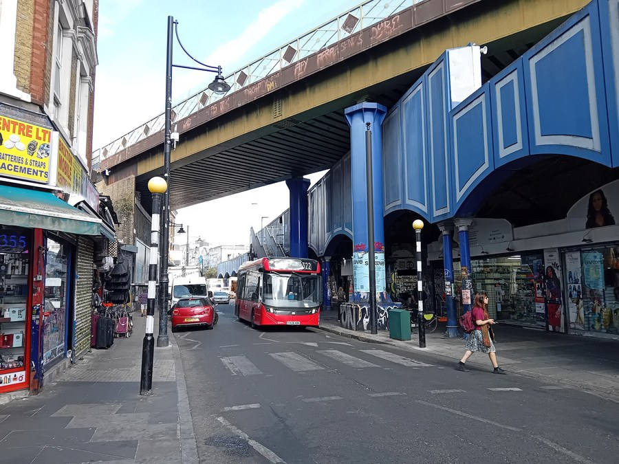 A London bus passing under the railway bridge in Brixton