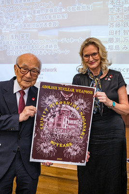 Terumi Tanaka and Melissa Parke holding a
poster marking 80 years of the nuclear weapons era