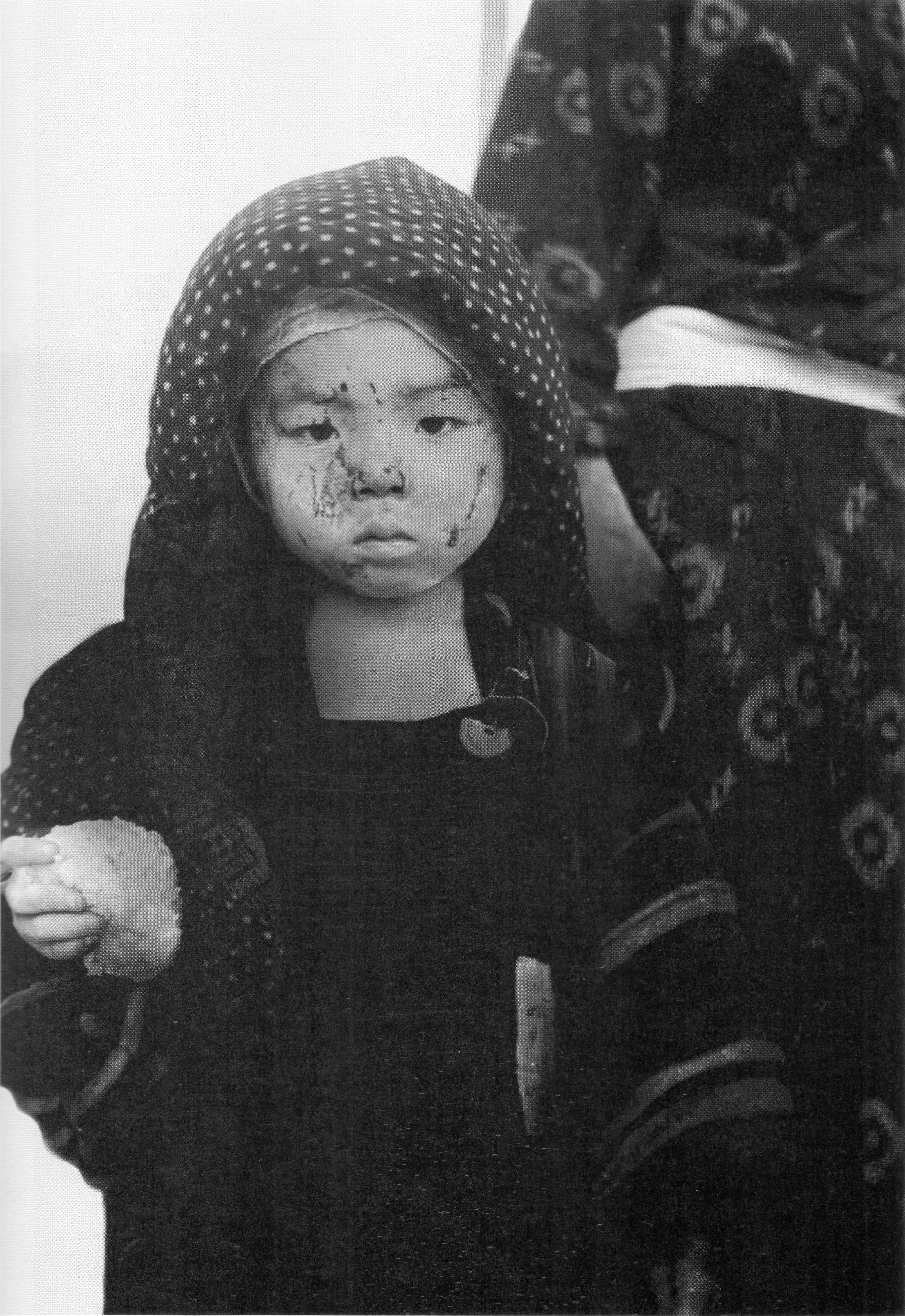 Um menino em Nagasaki recebe comida racionada no rescaldo do ataque. Crédito: Yosuke Yamahata