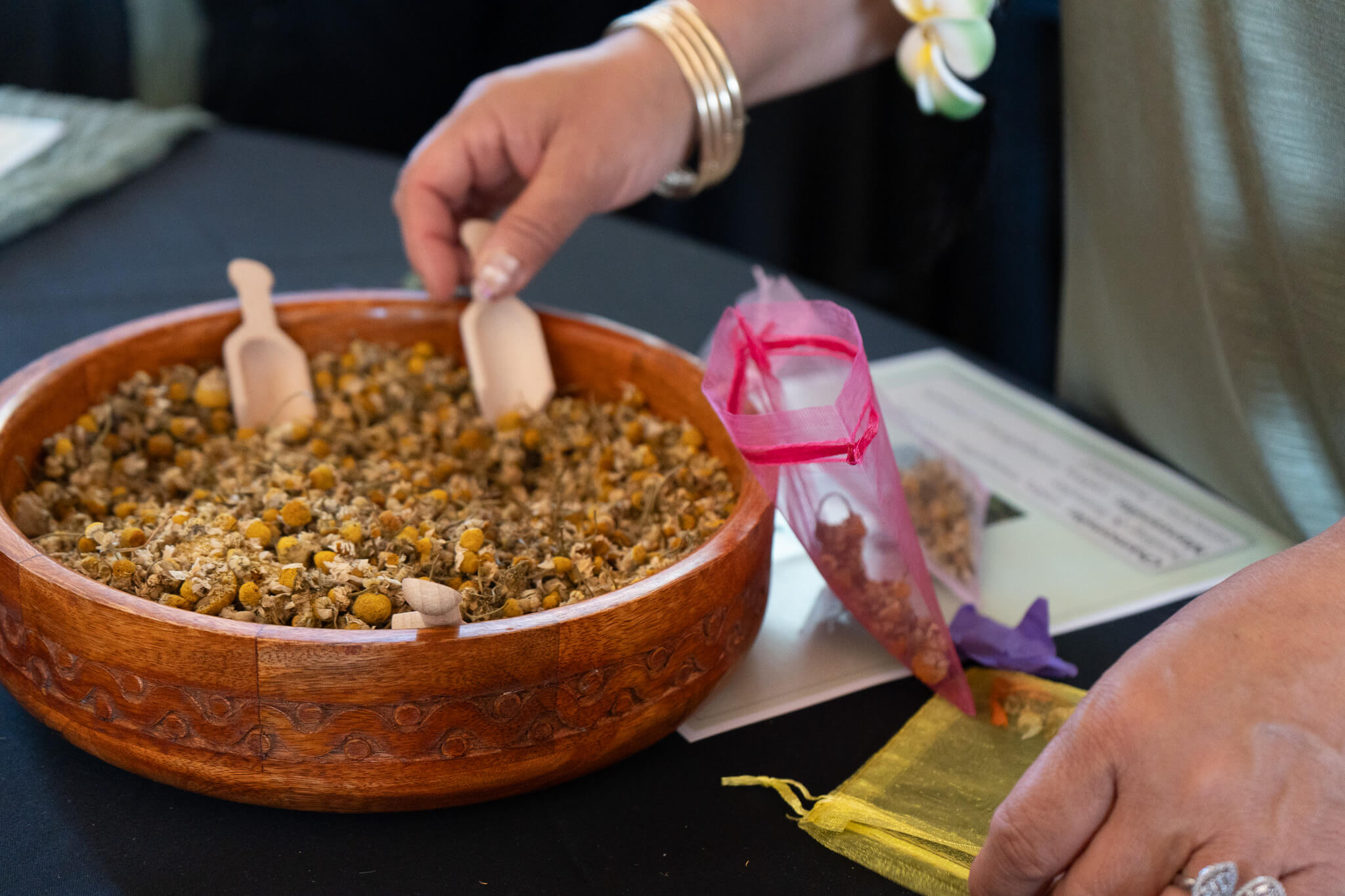 Someone putting chamomile flowers in a little bag