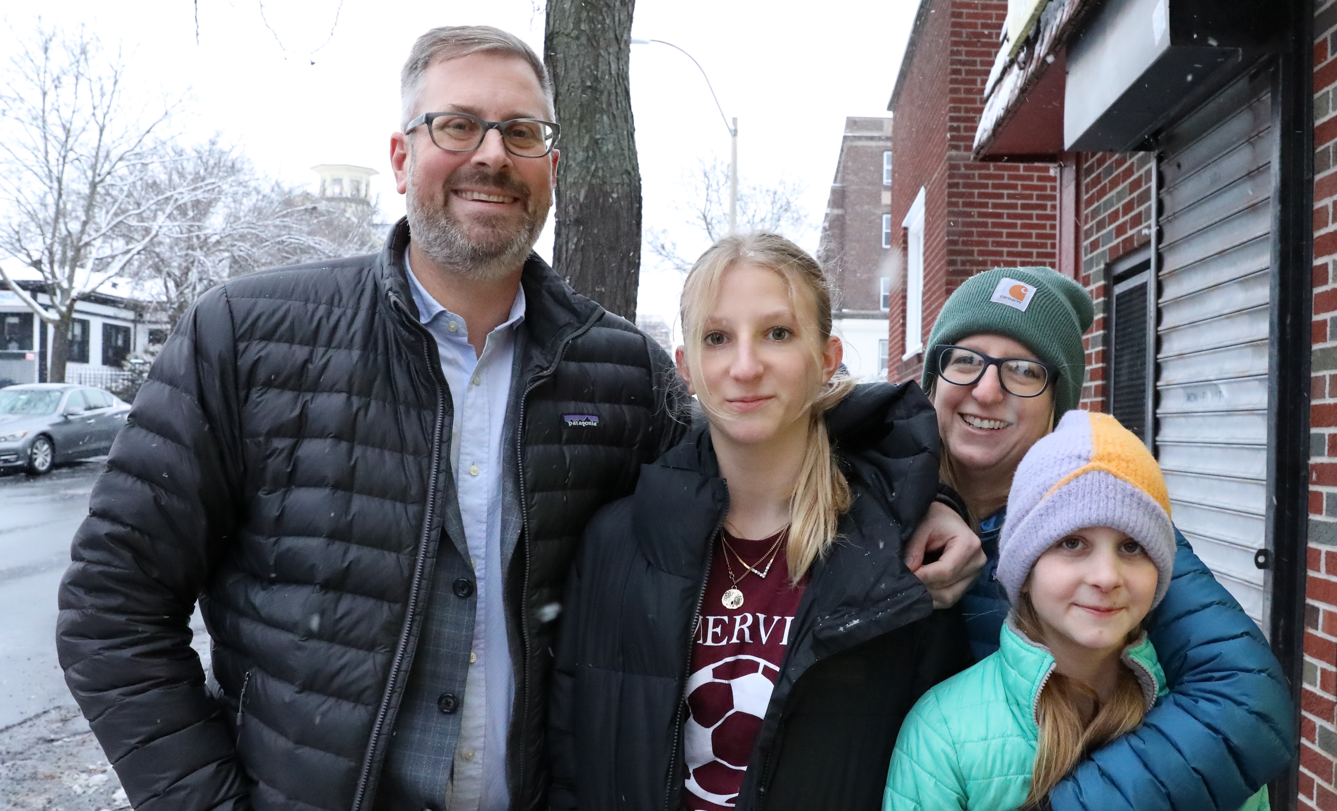 Jake poses with his family, three people to his right, on an overcast winter day.