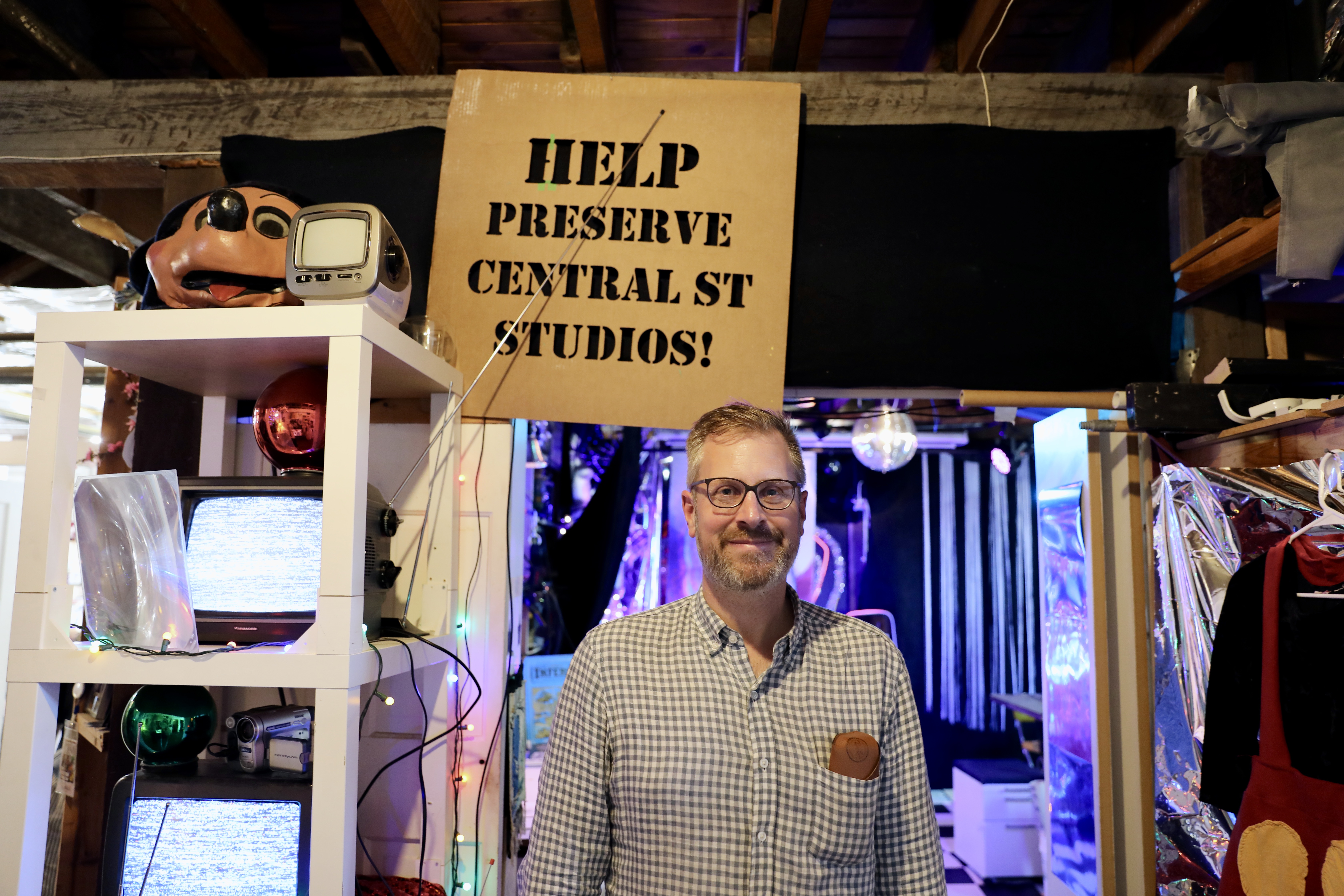 Jake smiling in front of a sign that reads \