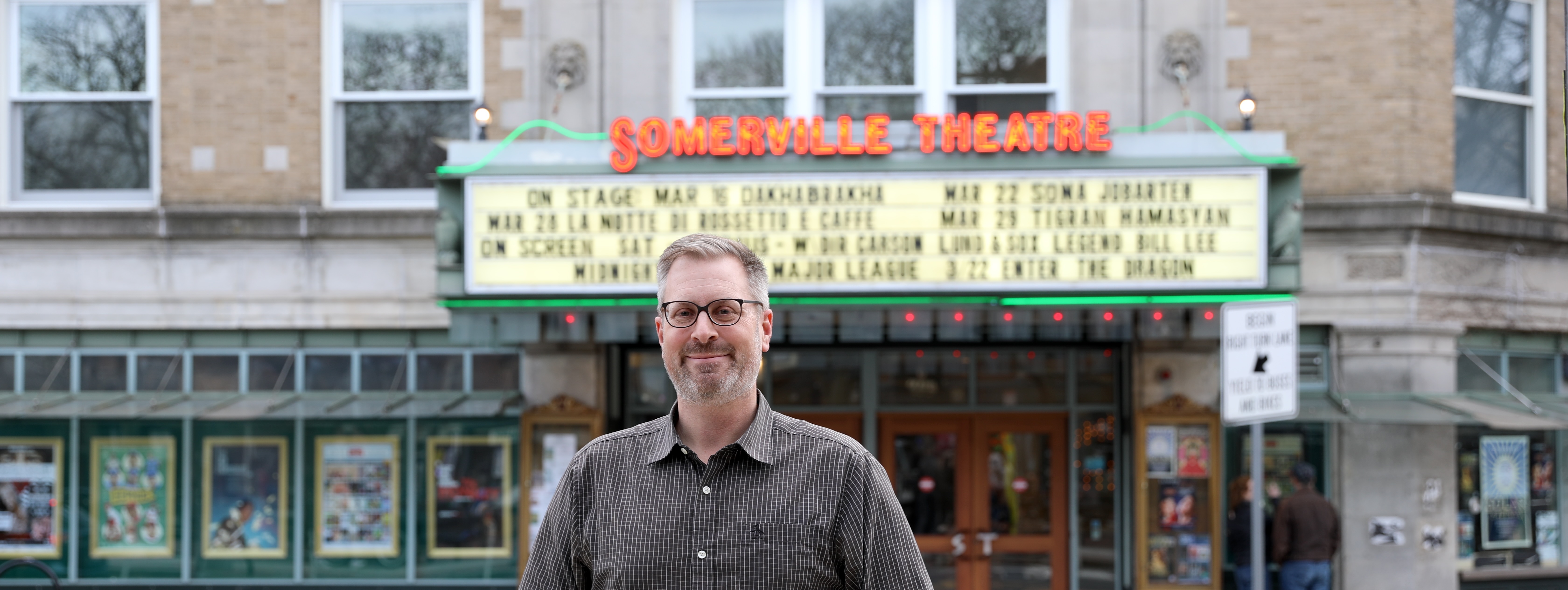 Jake standing in front of the Somerville theater
