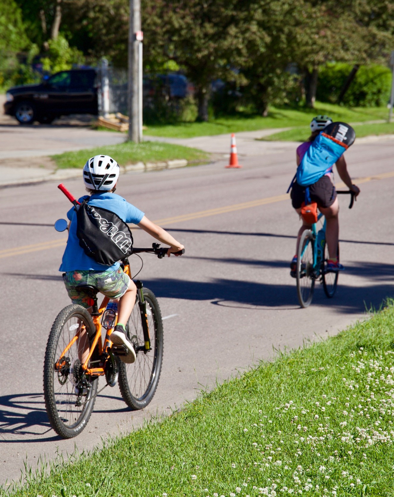 two children ride on a road with no shoulder or bike lane