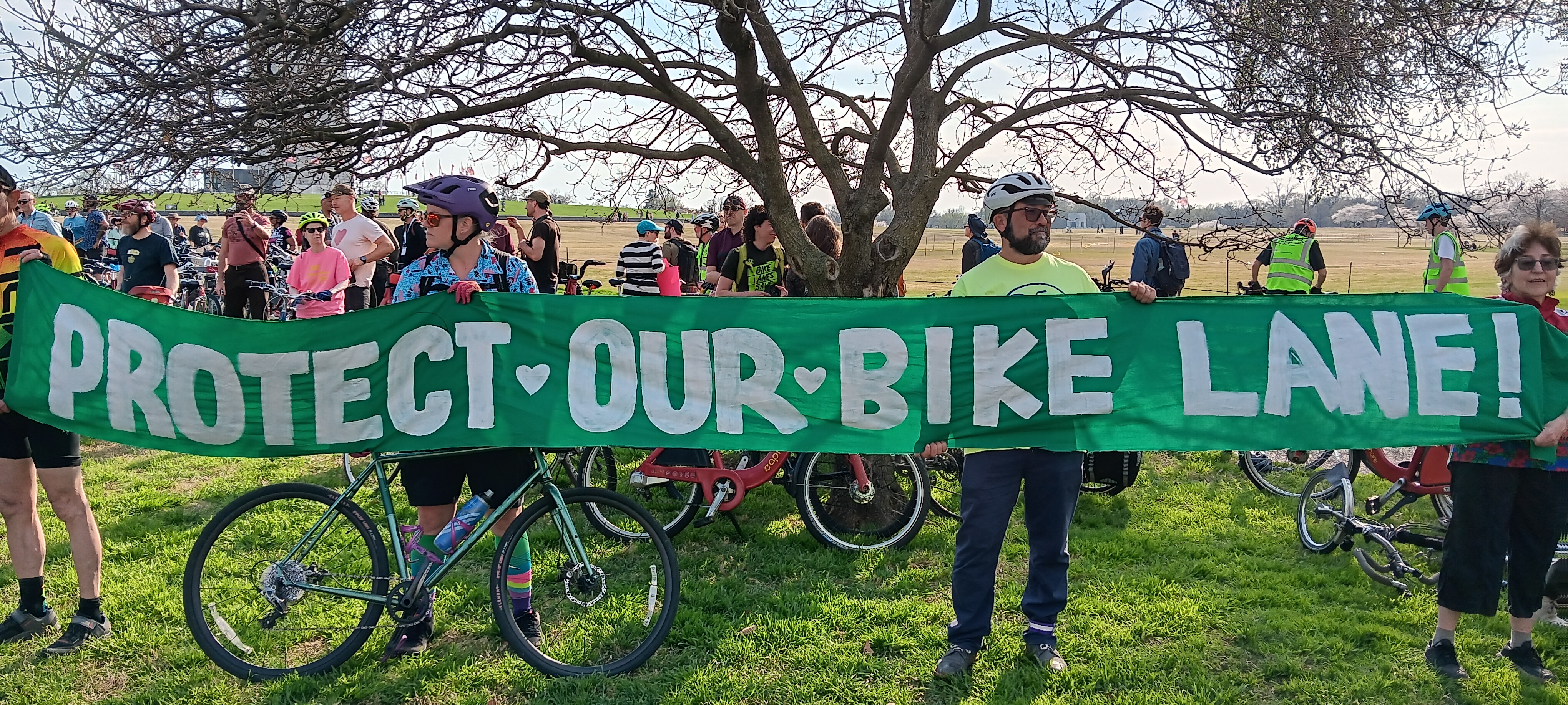 4 protesters holding a long handmade sign that reads \