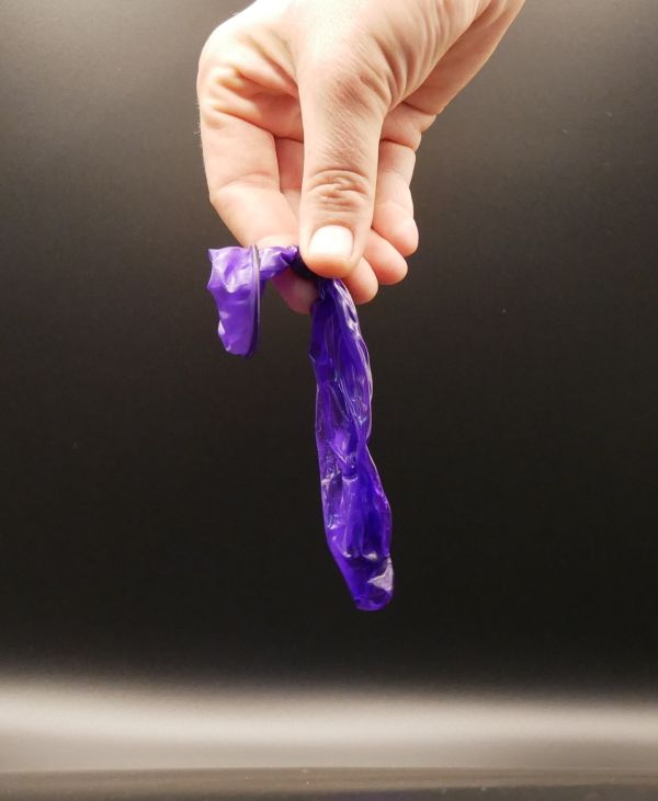 Image of a condom after being removed from a sex toy, with a knot tied in it.