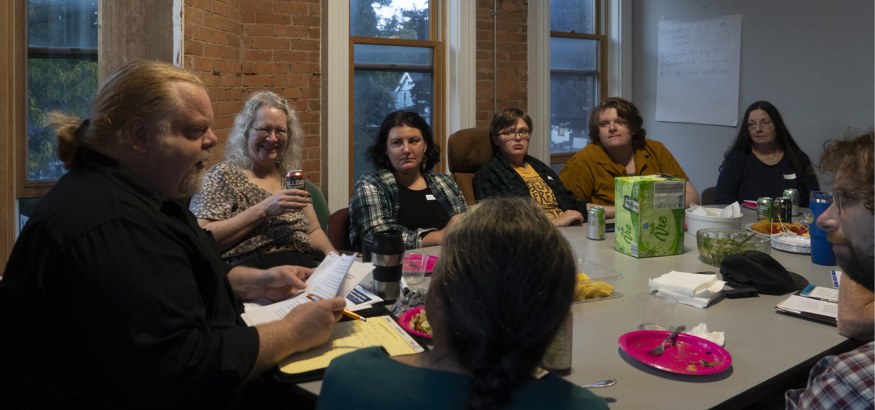 People sitting around a table with a speaker at one end