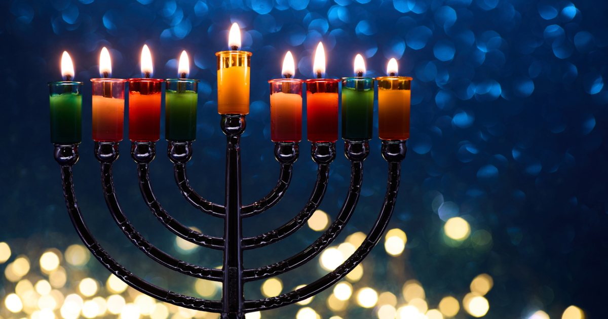 Hanukkah Menorah with burning candles on dark background with bokeh lights