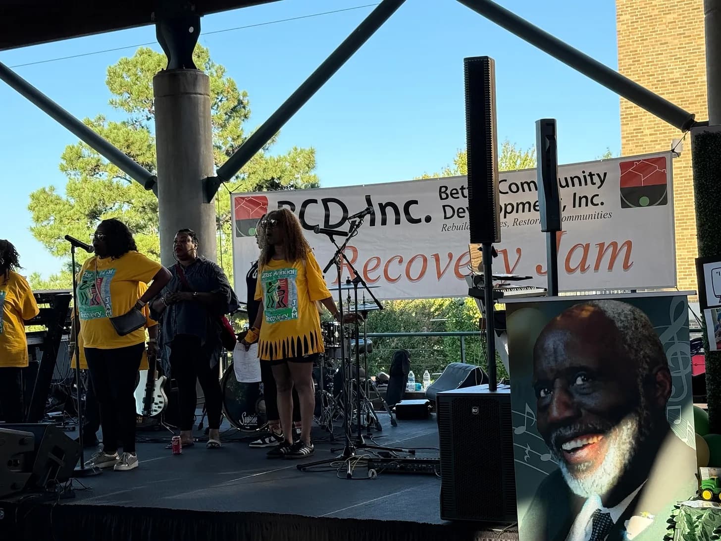 Performers in yellow shirts on stage under a ‘Recovery Jam’ banner