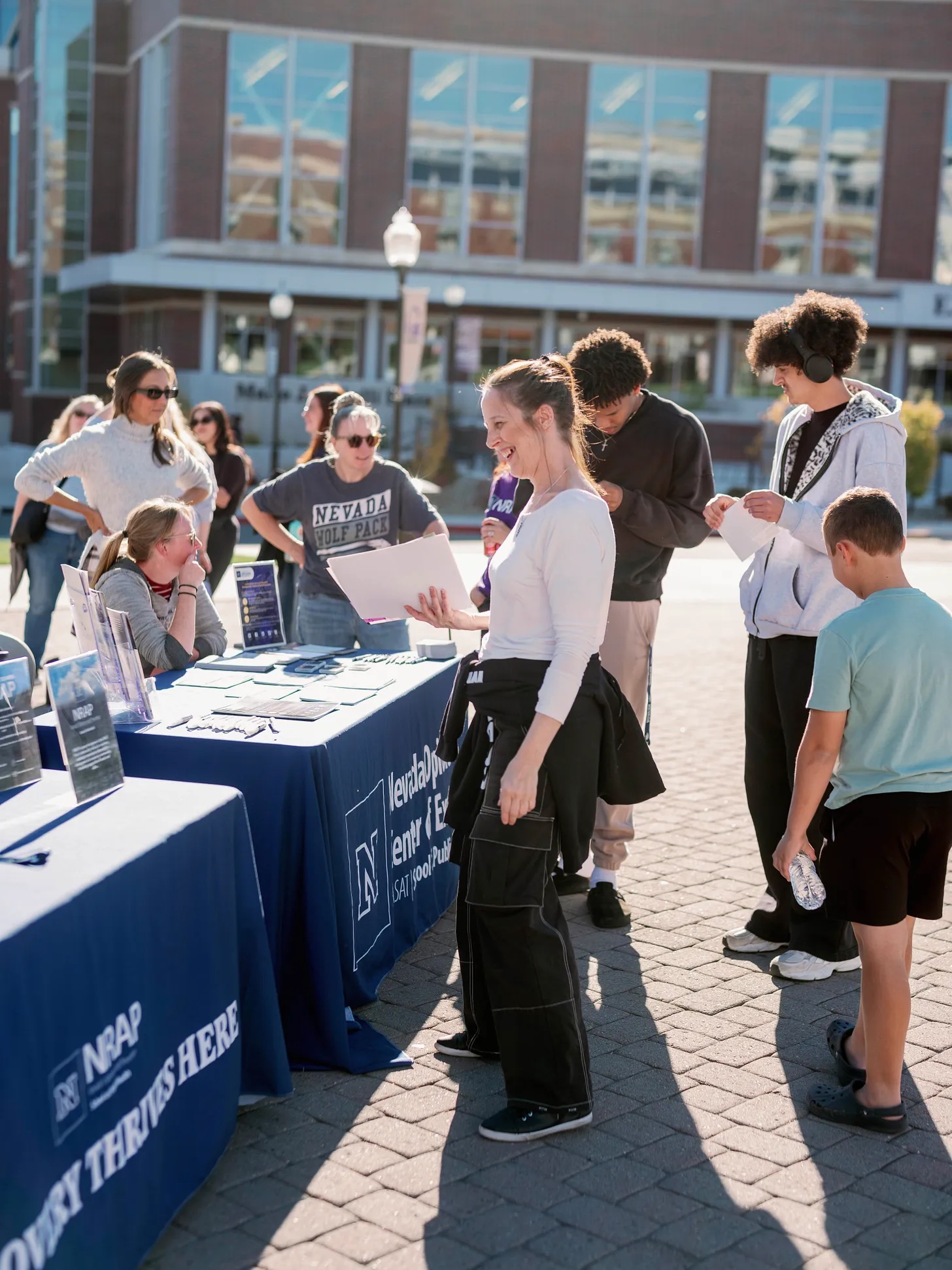 Woman smiling in front of information booth at Campus Surge Reno event