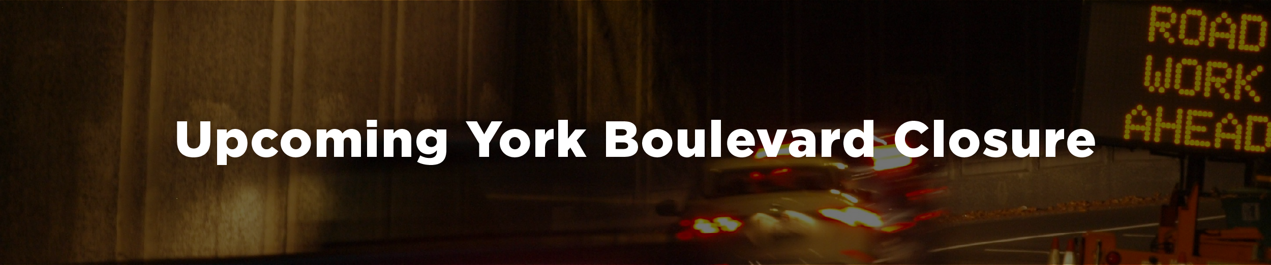 A construction scene at night with an illuminated sign reading "Road Work Ahead" and the overlaid text "Upcoming York Boulevard Closure"