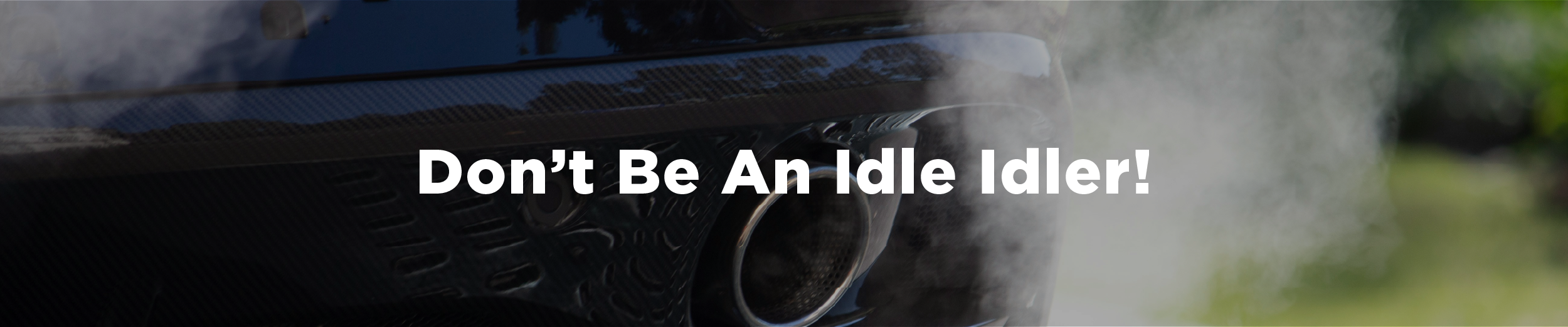 A car idling with exhaust pouring out of its tailpipe and the overlaid text "Don't Be An Idle Idler!"