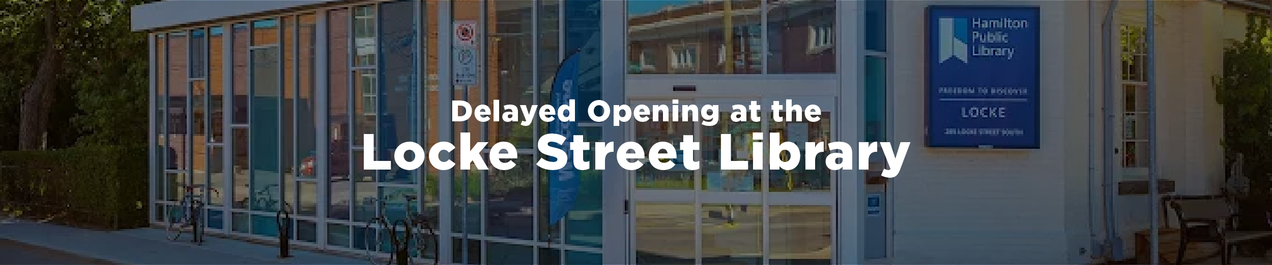 Photograph of the Locke Street Library branch in the summer with the overlaid text "Delayed Opening at the Locke Street Library"