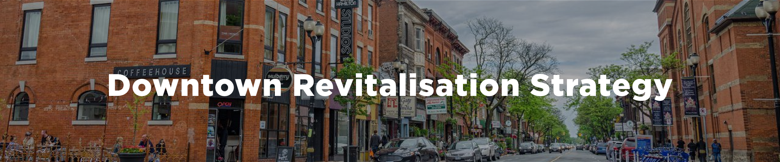 An image of downtown Hamilton at the corner of Mulberry and James with a series of midrise, mixed use buildings to the left and the Hamilton armoury on the right. The overlaid text reads "Downtown Revitalisation Strategy"