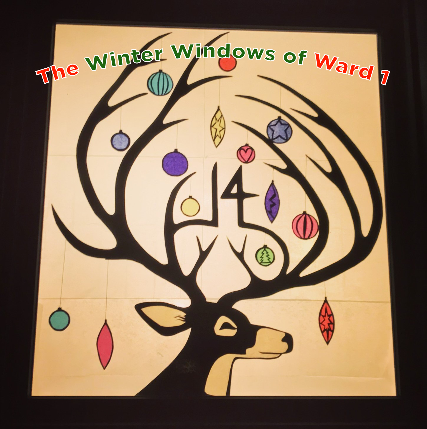 A winter window in Westdale featuring a festive deer that has ornaments on its antlers and the overlaid text "Winter Windows of Ward 1"