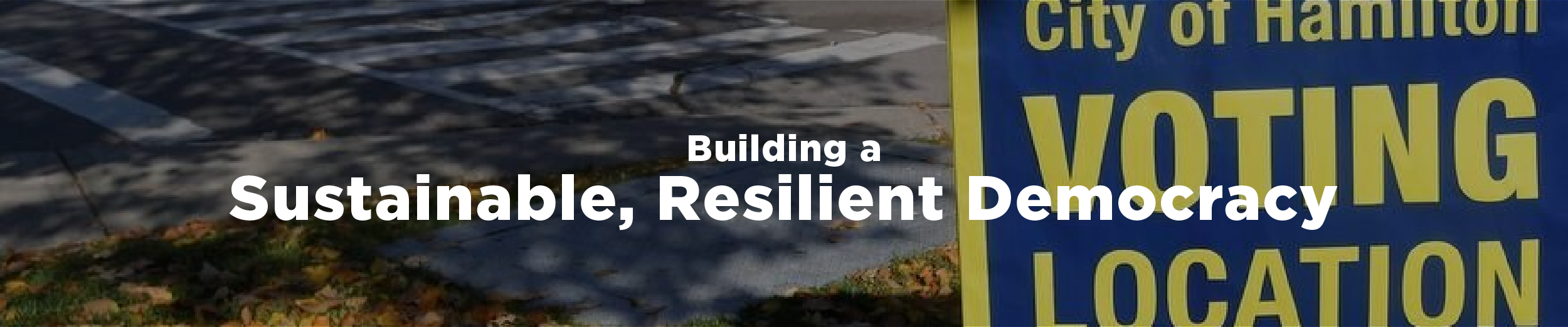 A City of Hamilton voting location sign on a sunny day in October of 2022 with changing leaves all around and the overlaid text "Building a sustainable, resilient democracy"
