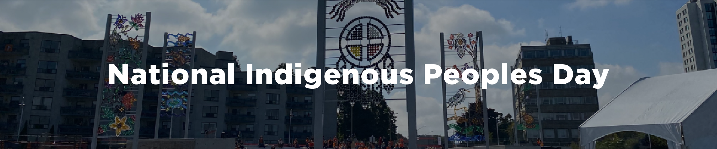 An image of the waterfront plaza with Indigenous public art on a summer day with the overlaid text "National Indigenous Peoples Day"